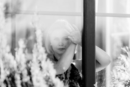 Pensive Woman Behind Window â Thoughtful Sad Portrait in Soft Natural Lightの写真素材