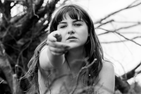 Powerful Nature Portrait of a Young Woman Reaching Outの写真素材