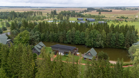Aerial view of ZelvÄ Village & SPA, a countryside resort near Sventoji, Palanga, Lithuania. Wooden cottages, lake, and forest surroundings with modern spa facilities and sports areas. 07 29 2025の写真素材