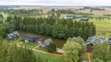 Aerial view of ZelvÄ Village & SPA, a countryside resort near Sventoji, Palanga, Lithuania. Wooden cottages, lake, and forest surroundings with modern spa facilities and sports areas. 07 29 2025の写真素材