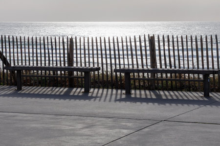 A rustic wooden sand fence along the beach in Lacanau, France, protecting sand dunes from erosion....