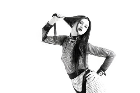 A striking portrait of a powerful woman in dark minimalist fashion. Strong pose, fishnet outfit, artistic aesthetic, modern editorial energy and confident feminine dominance.の写真素材