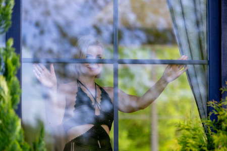 A woman framed behind glass, blending softness, mystery and nature. Light, reflections and silence...
