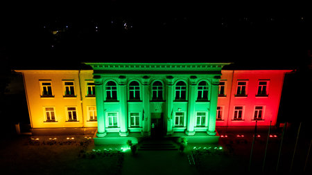 Kazlu Ruda municipality building in Lithuania illuminated with the national tricolor flag colors at night. Architectural facade lighting creates a patriotic, festive and symbolic scene perfect for tourism and celebration themesの写真素材