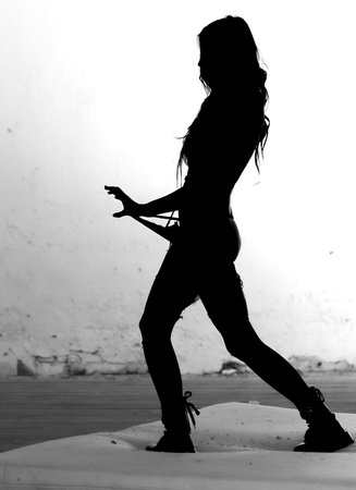 Artistic studio series showing dynamic body movement with fabric, tension and expressive poses. Silhouettes, clean lines and controlled motion captured in dramatic light for creative visual concepts.の写真素材