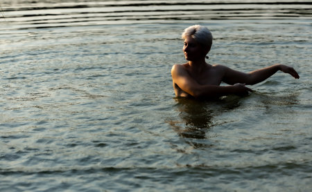 Woman in the sunset, in the water