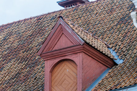 Traditional red clay tiled roofs and historic architecture in Tallinn old town, Estonia. Detailed roof textures, chimneys and dormer windows. European heritage architecture, urban background, no people.の写真素材