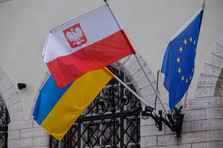 Poland â Polish, Ukrainian and European Union flags displayed together on the facade of a historic building. Visual symbol of European solidarity, unity and support for Ukraine in the current geopolitical contextの写真素材