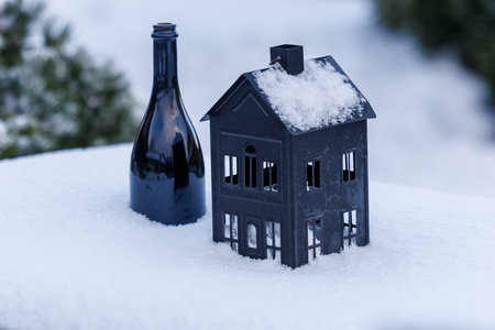 Small decorative house lantern covered with fresh snow outdoors. Minimal winter scene with soft natural light, shallow depth of field and clean background. Suitable for winter, holiday and seasonal conceptsの写真素材