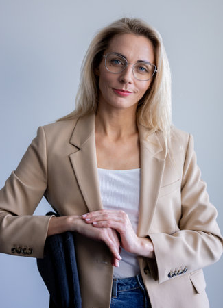 A cheerful business girl in a sand-colored jacket