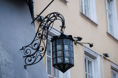 Close-up of ornate historic street lamps and wall lantern in Tallinn Old Town, showcasing wrought iron details and classic European architecture in soft winter light.の写真素材