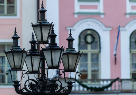 Close-up of ornate historic street lamps and wall lantern in Tallinn Old Town, showcasing wrought iron details and classic European architecture in soft winter light.の写真素材