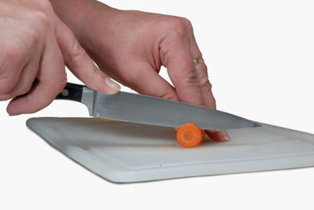 Hands of woman with a knife cut the carrots