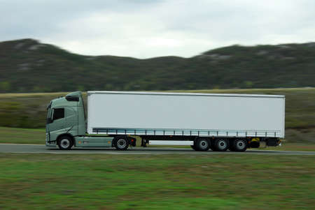 green lorry with white trailer drive fast