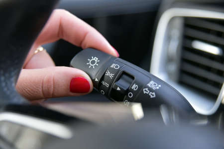 Female finger on the button to activate car lightingの写真素材