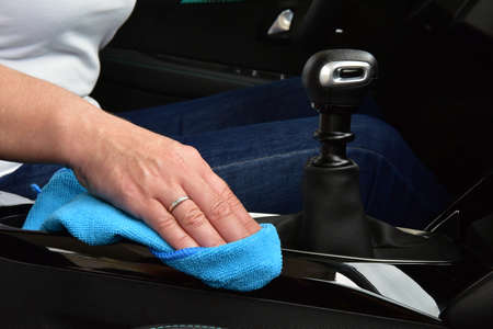 Cleaning the car console with a microfiber cloth