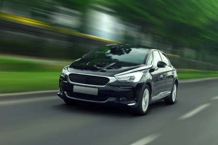 A panning shot of a speeding black car. Passenger car at high speed.の写真素材