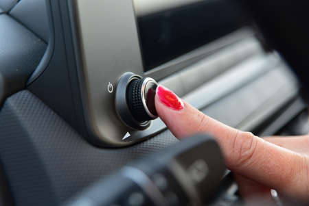 Female finger on the volume up button and the on and off buttonの写真素材