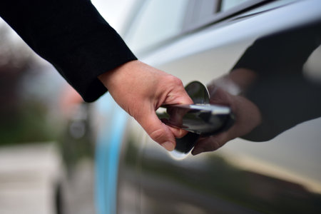 A woman opens the door of a passenger carの写真素材
