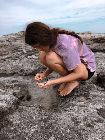 Young girl volunteering collecting plastics from the beach