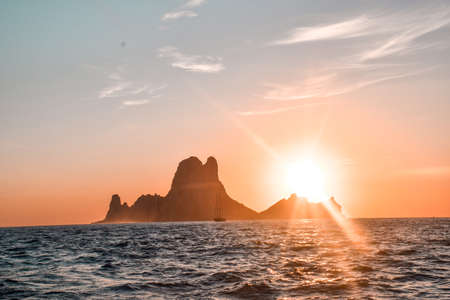 View from a ship of an island against light with the sunset behindの写真素材