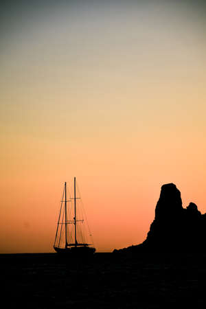 silhouette of a sailing boat sailing with mountain backgroundの写真素材