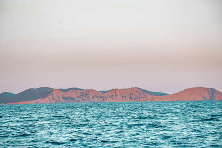 Cliff into the Mediterranean ocean. View from a sailboat