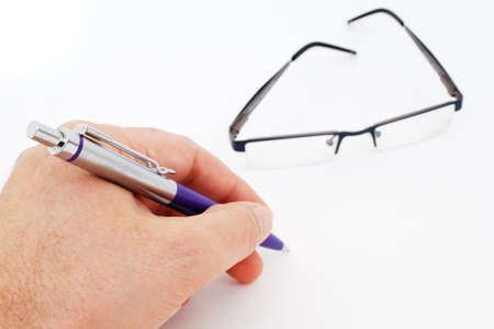 Hand writing, and glasses isolated on white background.の写真素材