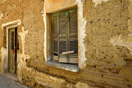 Fragment wall of old abandoned building with cracked door and window の写真素材
