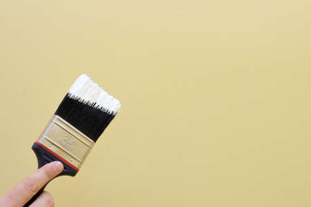 Hand with brush going to paint a wall の写真素材