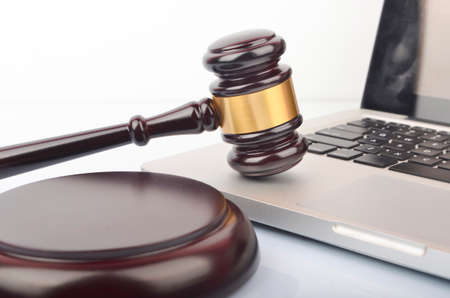 Cyber crime concept. Judge hammer or gavel with laptop on white background.