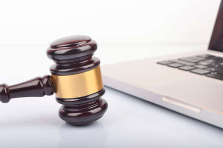 Cyber crime concept. Judge hammer or gavel with laptop on white background.