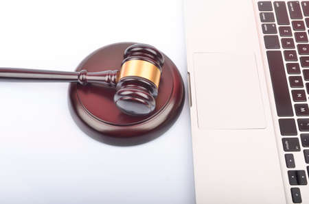 Cyber crime concept. Judge hammer or gavel with laptop on white background.の写真素材
