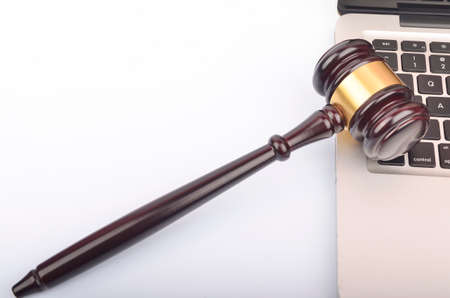 Cyber crime concept. Judge hammer or gavel with laptop on white background.