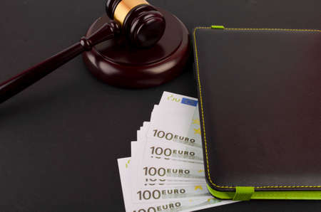 Gavel for judge lawyer with Euro banknotes on black background.