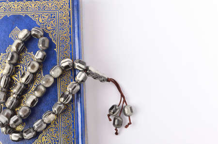 Holy Quran with arabic calligraphy meaning of Al Quran and tasbih or rosary beads