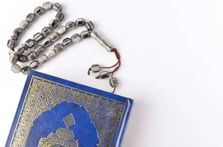Holy Quran with arabic calligraphy meaning of Al Quran and tasbih or rosary beadsの写真素材