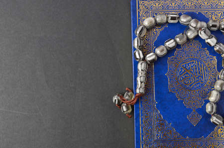 Holy Quran with arabic calligraphy meaning of Al Quran and tasbih or rosary beadsの写真素材