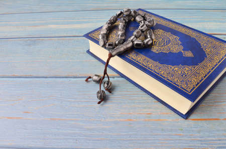 Holy Quran with arabic calligraphy meaning of Al Quran and tasbih or rosary beads