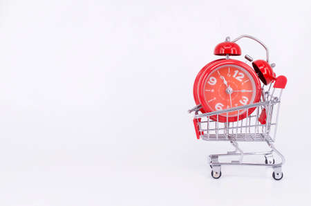 Shopping cart and classic alarm clock on white background. Sale time buy mall market shop consumer...