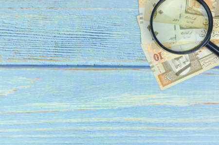 Saudi Arabia money on wooden background.