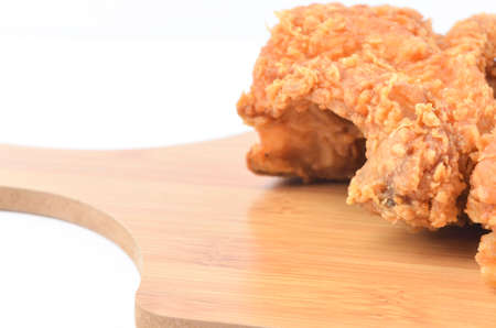 Fried chicken on wooden board isolated on white background.
