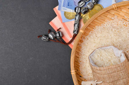 Coins, rosary, Holy Quran and rice in the sack. Zakat concept. Zakat is a form of alm-giving as a...