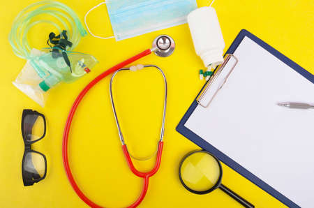 Flat lay view of medical and healthcare background concept. Space for your text. Top view essential items for doctor using treat and care patient in hospital. Object on yellow background.の写真素材