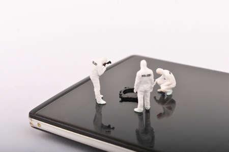 Miniature people ; Police and detective are working on smartphone, Crime Scene Investigation, cyber crimes concept. Selective focus.の写真素材