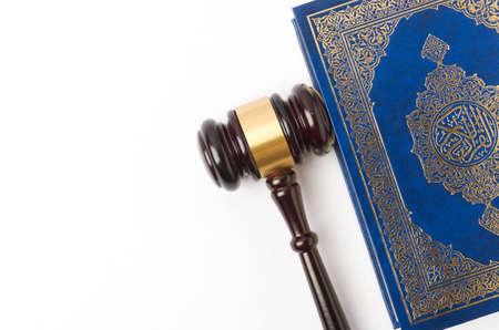 Top view image of Quran with law gavel on white background. Sharia or Islamic law concept. Large...