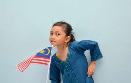 Malay girl holding Malaysia flag. Malaysia independence concept. Selective focus.の写真素材