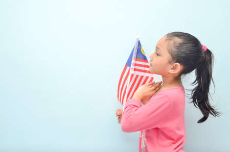 Malay girl holding Malaysia flag. Malaysia independence concept. Selective focus.の写真素材