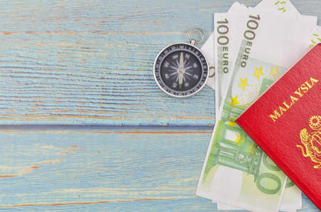Passport and banknotes on wooden background. Vacation foreign travel or world tour budget plan.の写真素材