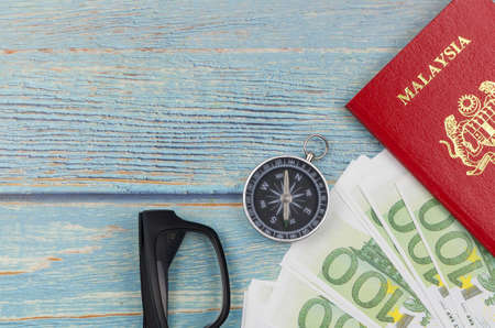 Passport and banknotes on wooden background. Vacation foreign travel or world tour budget plan.